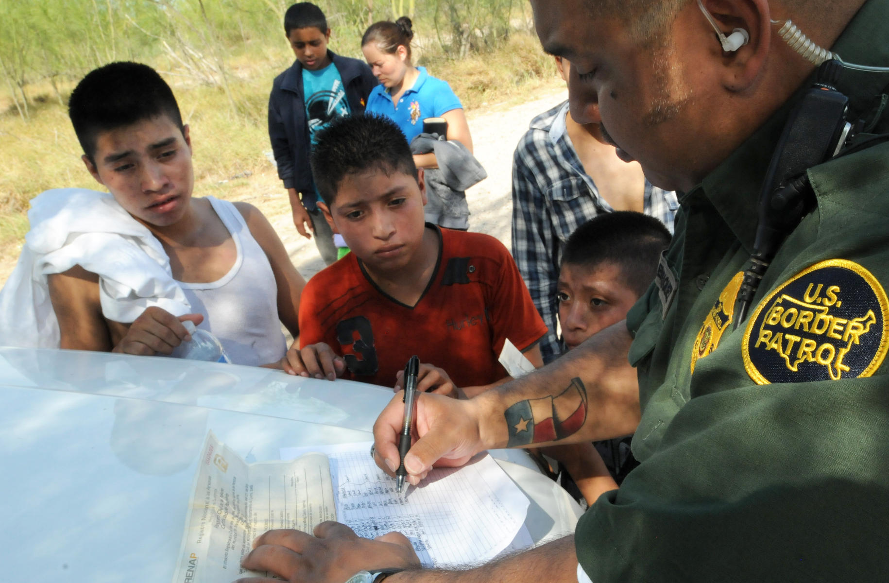 A Border Patrol Officer records the names of Central American children apprehended for illegally entering the U.S. from Mexico. 